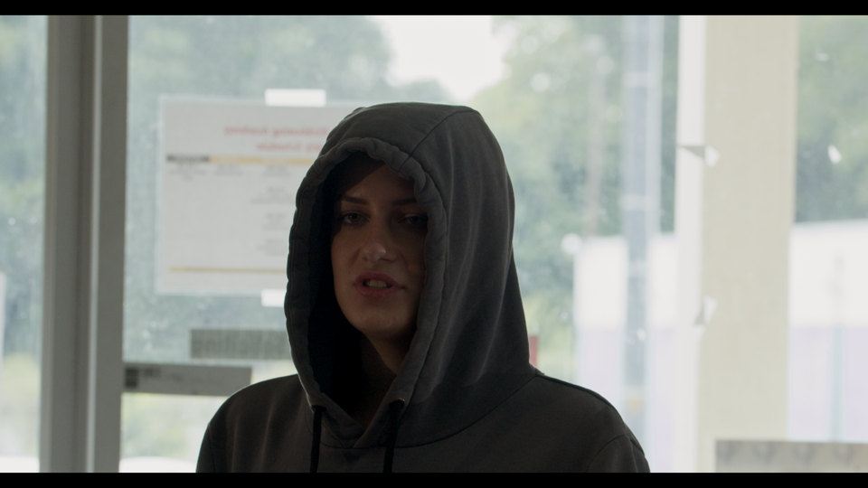 A woman in a hood by the window